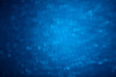 Blue Puzzle shape bokeh. Defocused background for autism awareness day. Real photo. Light blue
