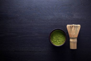 Kibrit tozu. Organik yeşil kibrit çay seremonisi. Sağlıklı bir içki. Geleneksel Japon içkisi siyah tahta arka planda.