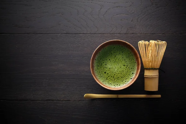 Matcha w proszku. Organiczna ceremonia zielonej herbaty matcha. Zdrowy drink. Tradycyjny japoński napój na czarnym drewnianym tle — Zdjęcie stockowe