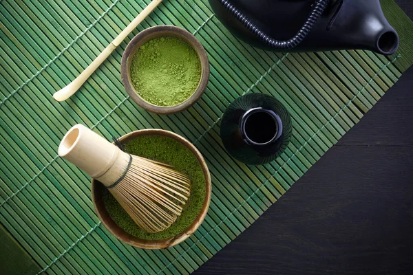 Matcha powder. Organic green matcha tea ceremony. Healthy drink. Traditional japanese drink on black wooden background