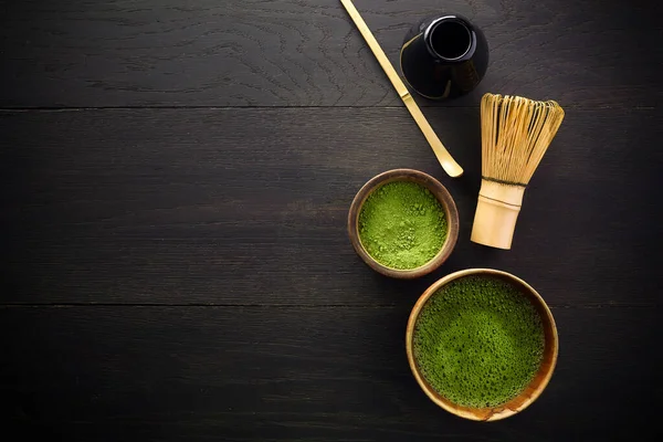 Matcha w proszku. Organiczna ceremonia zielonej herbaty matcha. Zdrowy drink. Tradycyjny japoński napój na czarnym drewnianym tle — Zdjęcie stockowe