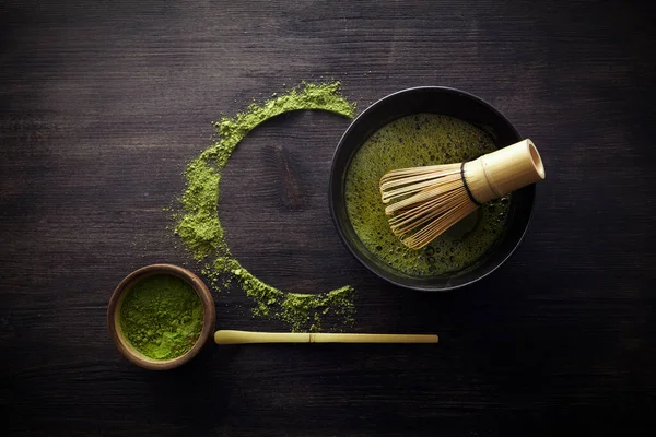 Matcha por. Organikus zöld matcha tea szertartás. Egészséges ital. Hagyományos japán ital fekete fa háttér — Stock Fotó