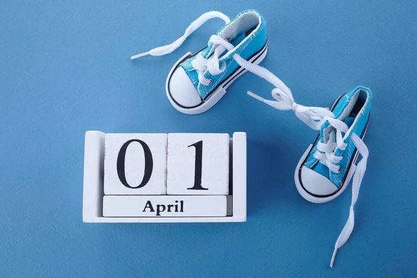 April fools day. Surprise symbol. Shoelaces tied together on blue wooden background. April fool.