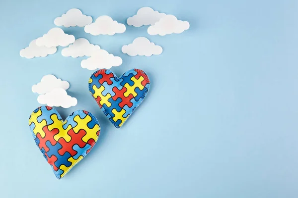 Día mundial de la conciencia del autismo. Concepto de concienciación sanitaria. Puzzle corazones en el cielo azul . — Foto de Stock