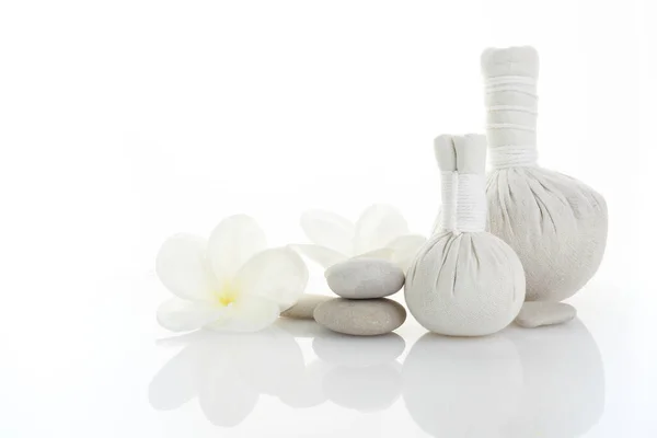 Spa white background plumeria and herbal compress balls. Spa massage. Zen stones balance. — Stock Photo, Image