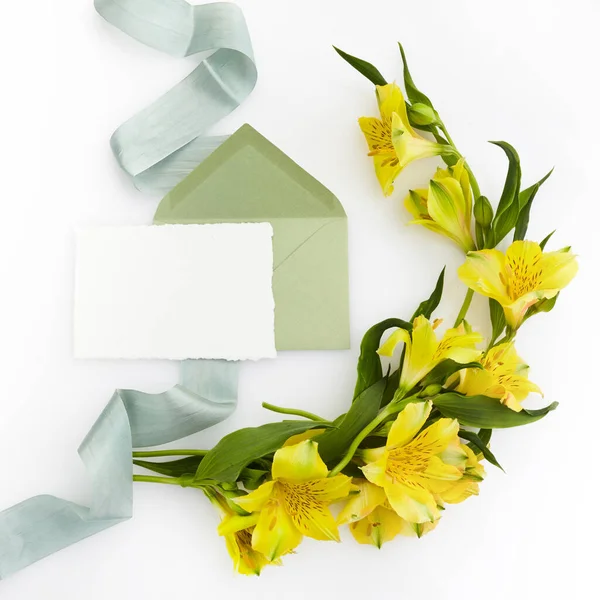 Carte de vœux blanche vierge avec enveloppe et fond blanc fleuri. Vue de dessus. Maquette — Photo