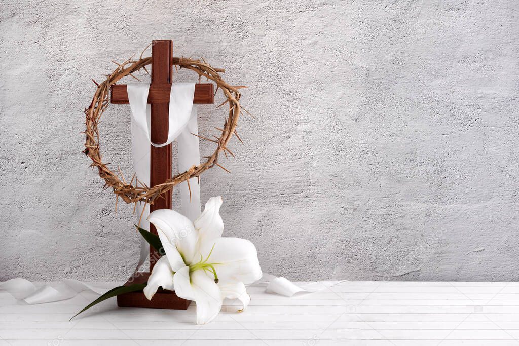 Composition with crown of thorns, wooden cross and lily on light background