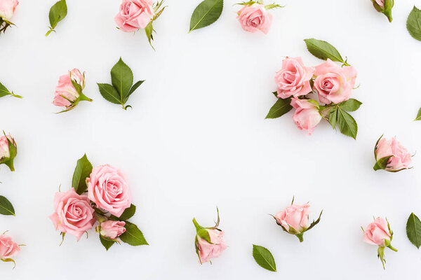 Framework from roses on white background. Flat lay. Top view