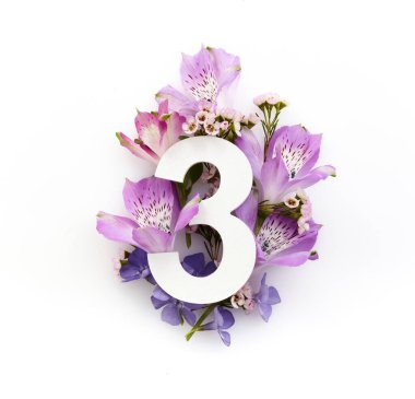 Renkli çiçekli yaratıcı bir düzen ve üç numara. Düz yatıyordu. Üst görünüm.