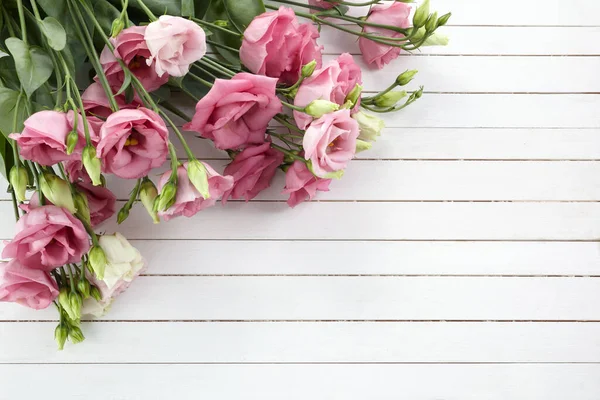 Рожеві квіти еустоми на дерев'яному тлі в вінтажному стилі. Романтичний весільний фон. Вид зверху . — стокове фото