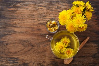 Eski ahşap arka planda bir fincan sağlıklı karahindiba çayı. Taze bitkiler..