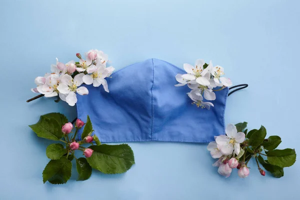 Twarzą do maski medycznej z kwiatami. Ochrona przed wirusami. Wiosenna moda — Zdjęcie stockowe