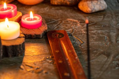 burning aromatic candles melted in rustic wood in low light