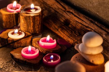 burning aromatic candles melted in rustic wood in low light