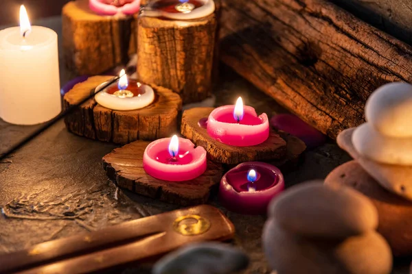 burning aromatic candles melted in rustic wood in low light