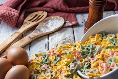 Kırsal masada yumurta ve biberin yanında renkli kuru erişte.