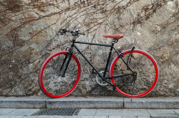 Una Bicicleta Roja Está Aparcada Junto Una Pared Piedra — Foto de Stock