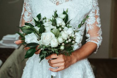 Gelin bir düğün buketi tutuyor.