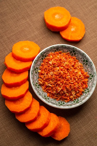 Plate of chopped carrots and a handful of dried carrots