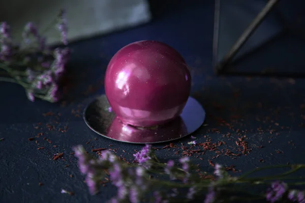 Délicieux dessert boule de chocolat chic sur fond sombre avec des fleurs de couleur violette Images De Stock Libres De Droits