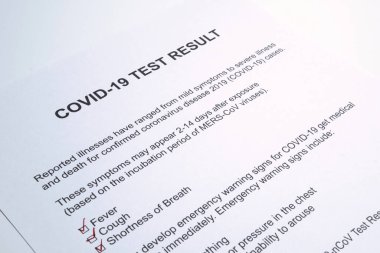 COVID-19 veya yeni koronavirüs salgını için pozitif test sonuçları. Stetoskop ve yeni koronavirüs testi doktor masasında sonuç veriyor.