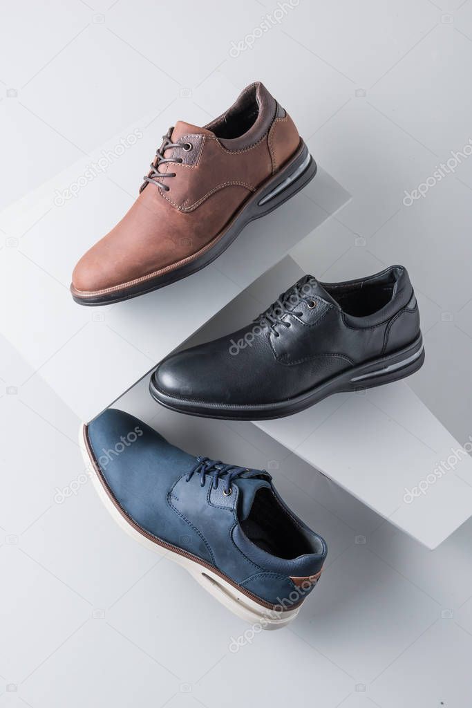 Dress and casual shoes for men on gray objects and gray background to paint in different colors, for shoes catalog