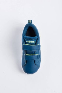 Köpek balığı çiziminin detaylarını taşıyan çocuklar için ADIDAS spor ayakkabıları, beyaz arka planda mavi renk