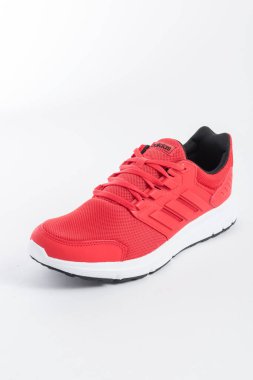 ADIDAS sneakers with brand details, red on white background