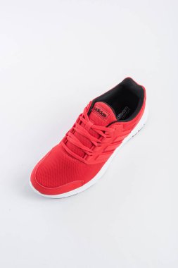 ADIDAS sneakers with brand details, red on white background