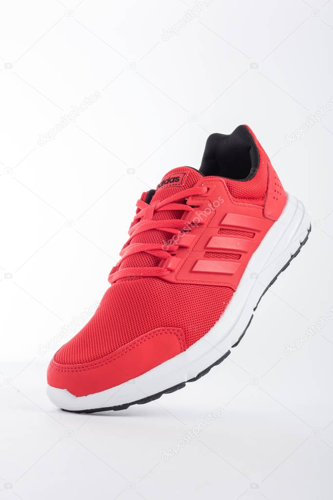 ADIDAS sneakers with brand details, red on white background