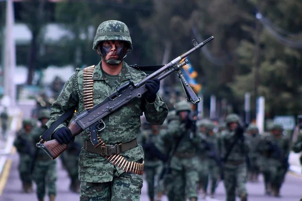 Meksika ordusu bir şarjörde silahlarla yürüyor.