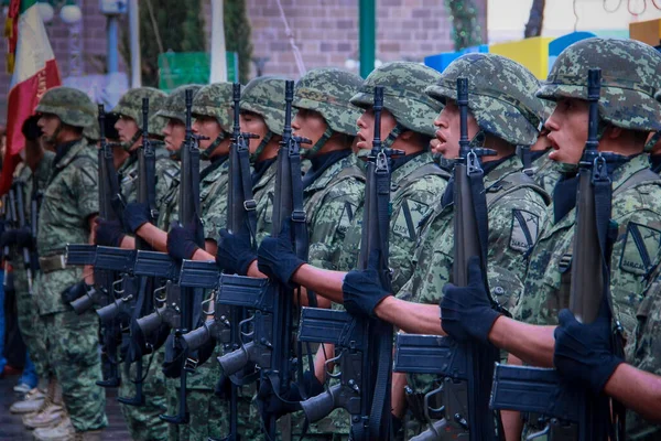 Meksika ordusu bir şarjörde silahlarla yürüyor.