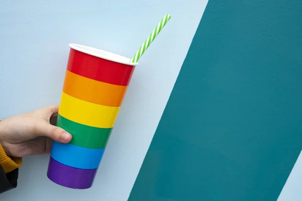 Hand picking up a party glass and pride. Pride party concept.