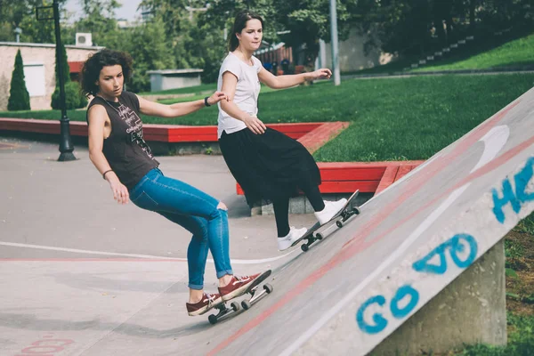 Dos chicas jóvenes disfrutan del skateboarding — Foto de Stock