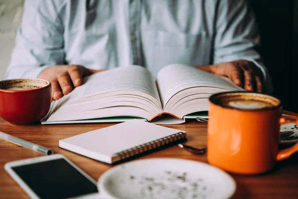 Person Som Dricker Kopp Kaffe Och Läser Bok Ett Café — Stockfoto