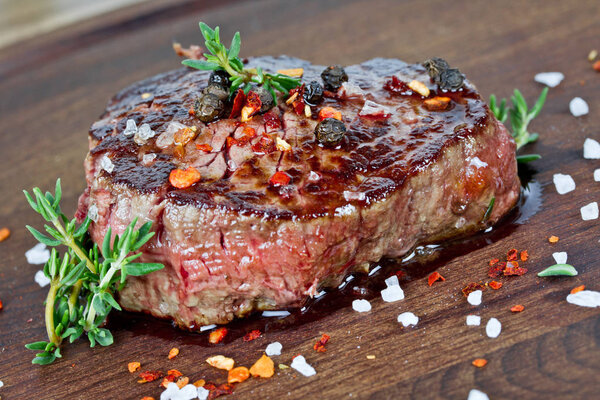Medium grilled steak on wooden plate