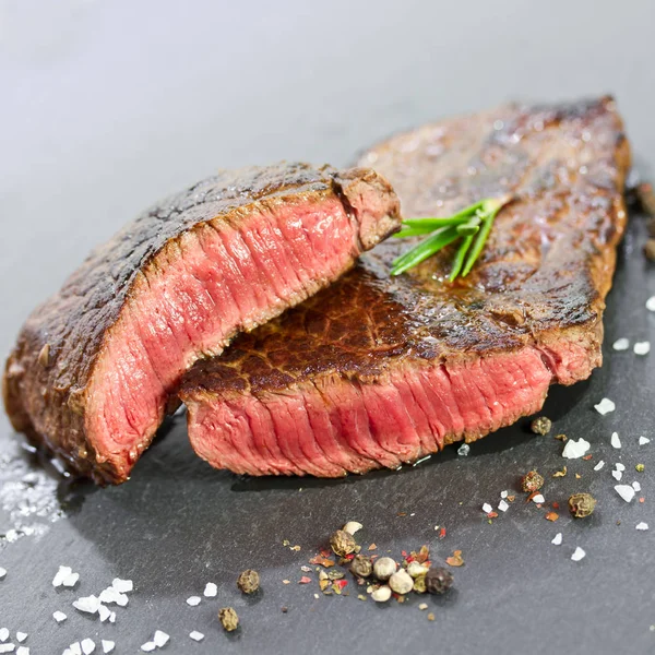 Střední grilovaný biftek se solí a pepřem Stock Obrázky