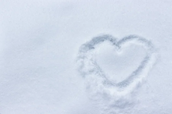 A heart is drawn in the snow. the concept of an ice heart is cold, cooling in a relationship