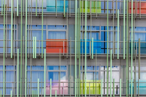 Фасад современного здания, абстрактное архитектурное решение, разноцветные прозрачные панели и металлические трубы в дизайне современного корпуса — стоковое фото