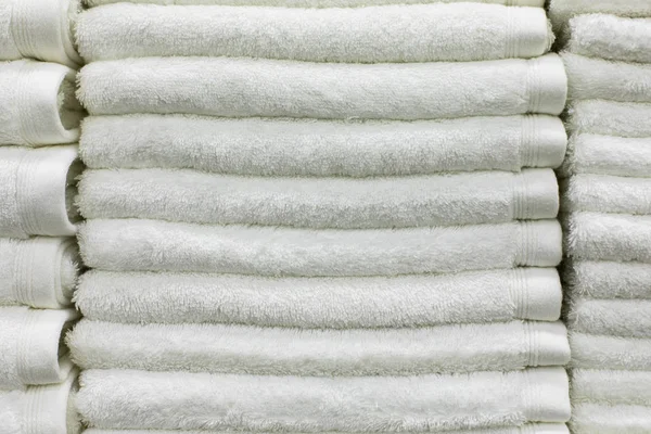 Пачка белых махровых полотенец в отеле. Текстиль для ванны и спа, набор чистых полотенец из салона красоты — стоковое фото