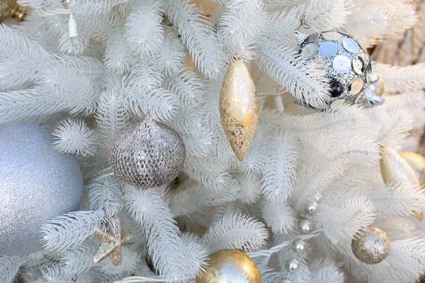 Decoraciones de oro de Año Nuevo juguetes en un árbol de Navidad de plástico blanco. Icicle bola estrella colgando en las ramas de abeto ecológico, fondo de diseño de telón de fondo — Foto de Stock