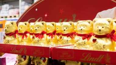 Moskova, Rusya - 30 Kasım 2019: Çikolata ayılarıyla reklam gösterisi. Lindt şenlikli çikolata ambalajı, kırmızı eşarplı çikolata ayıları ve taş kristal kalp.