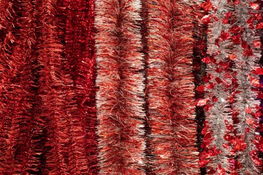 Kabarık polietilen iğneli folyo kırmızısı gümüş süsler, arka plan. Çizgiler politen folyodan yapılmış parlak kırmızı çelenk, dizayn için Noel süslemesi
