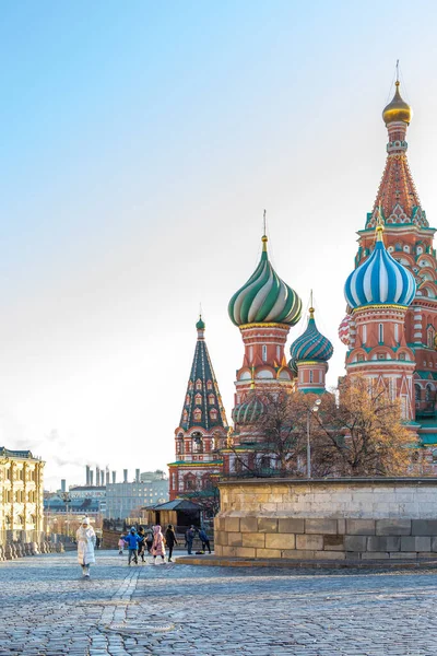 Moscú, Rusia - 1 de diciembre de 2019: Catedral de San Basilio en la Plaza Roja, un popular punto de referencia turístico, cielo azul claro, turistas divertidos. Cúpula azul verde de la catedral, pavimento adoquinado — Foto de Stock