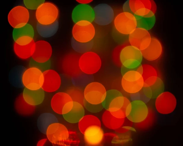 焦点がぼやけた電球、ラウンドレンズフレアボケの装飾。背景デザインは赤黄緑色。まばゆい光輝く光沢のある光とクリスマスのガーランド — ストック写真