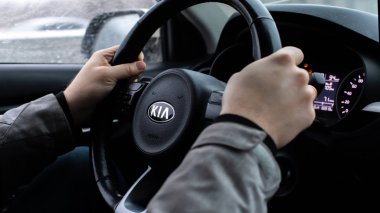 Moskova, Rusya - 2 Ocak 2020: Kia logolu siyah direksiyon simidi. Güney Koreli bir SUV Kia Rio X-Line 'ın şoförünün elleri. Araba sürücüsü
