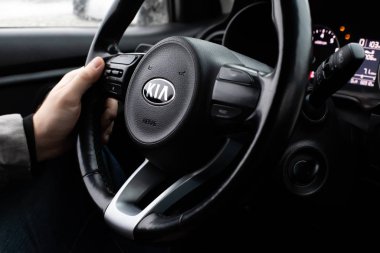 Moskova, Rusya - 2 Ocak 2020: Kia Rio X-Line 'ın direksiyonundaki erkek el. Logolu siyah direksiyon.