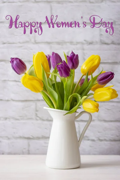 Happy Women\'s Day greeting card with a bunch of fresh natural yellow lilac tulips in a white jug. International Women\'s Day, congratulation with flowers