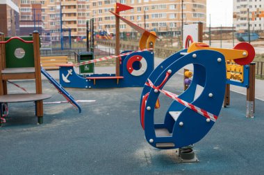 Bariyer bantla sarılı oyun alanı, evde kal. Salıncak ve atlıkarınca karantinası, Coronavirus covid-19 salgınının önlenmesi.