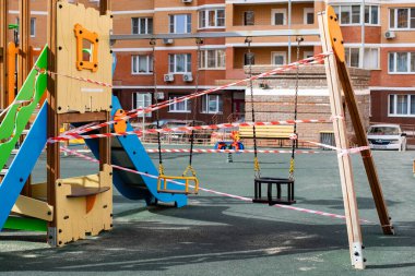 Moskova, Rusya - 5 Nisan 2020: salgın, koronavirüsü durdurun, evde kalın. Oyun parkı salıncağı, kırmızı kurdeleyi yasaklıyor, Coronavirus covid-19 sarar virüsü enfeksiyonunu önlüyor.